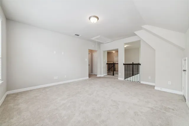 an empty room with windows and ceiling fan