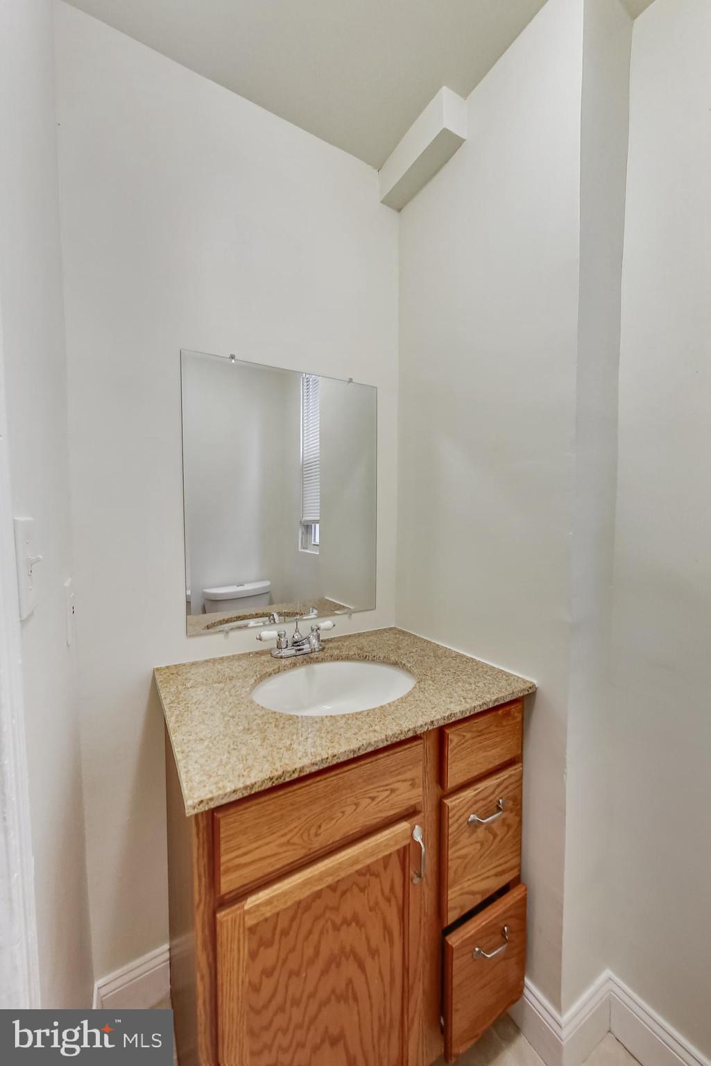 137 R Street Northeast Washington, DC 20002 - Photo 17 of 28 a bathroom with a granite countertop sink and a mirror