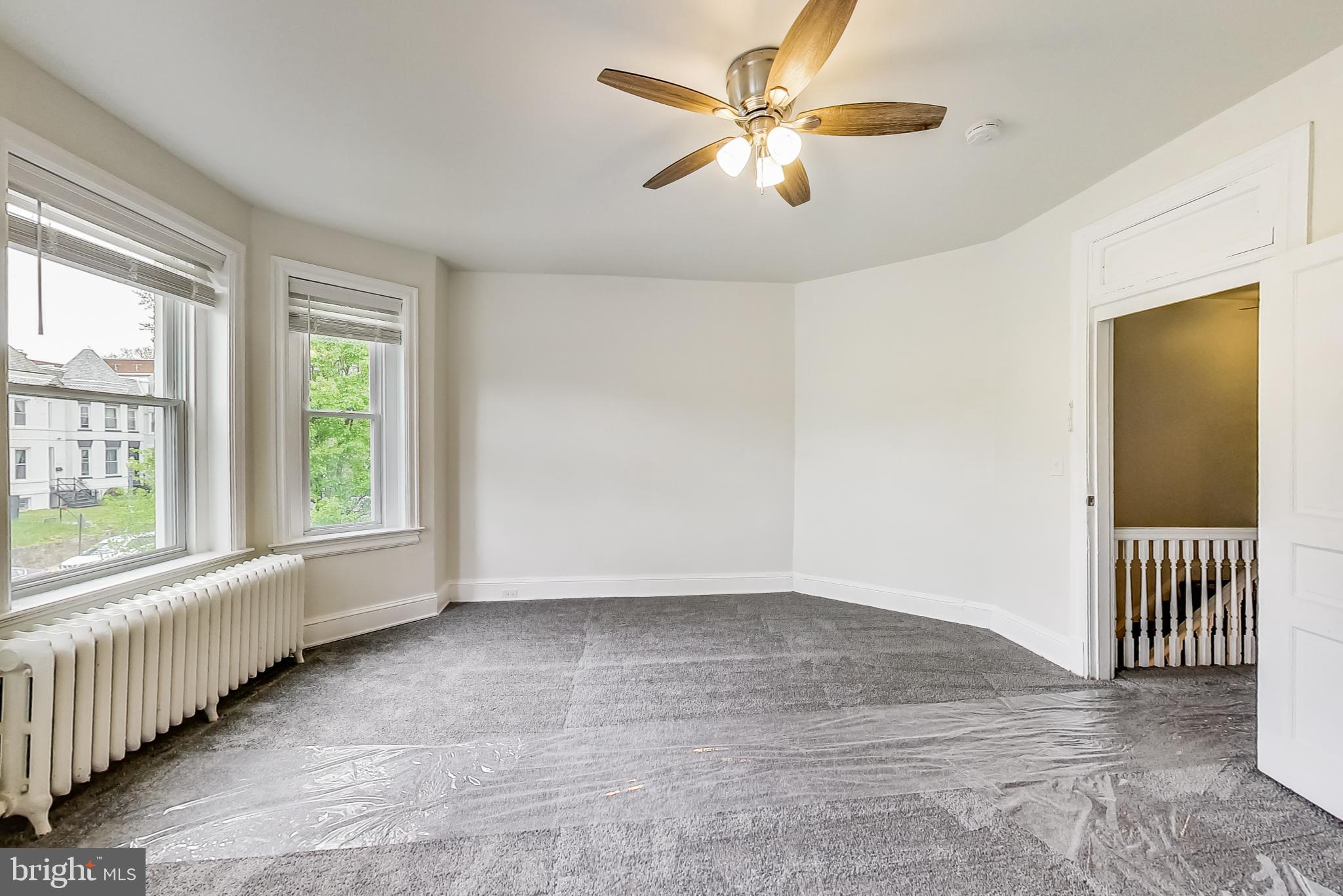 137 R Street Northeast Washington, DC 20002 - Photo 19 of 28 an empty room with windows and a chandelier fan