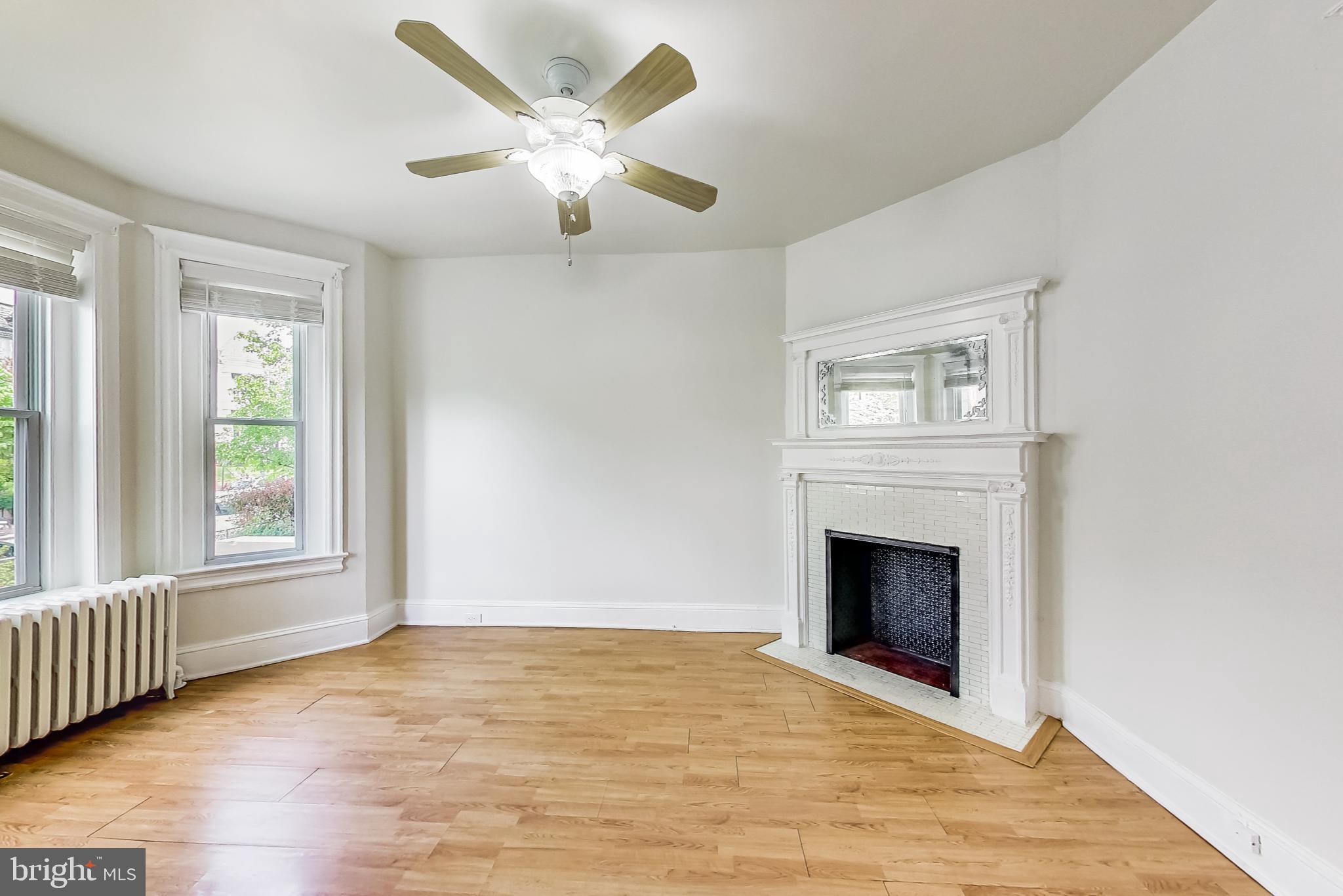137 R Street Northeast Washington, DC 20002 - Photo 6 of 28 an empty room with windows fireplace and wooden floor
