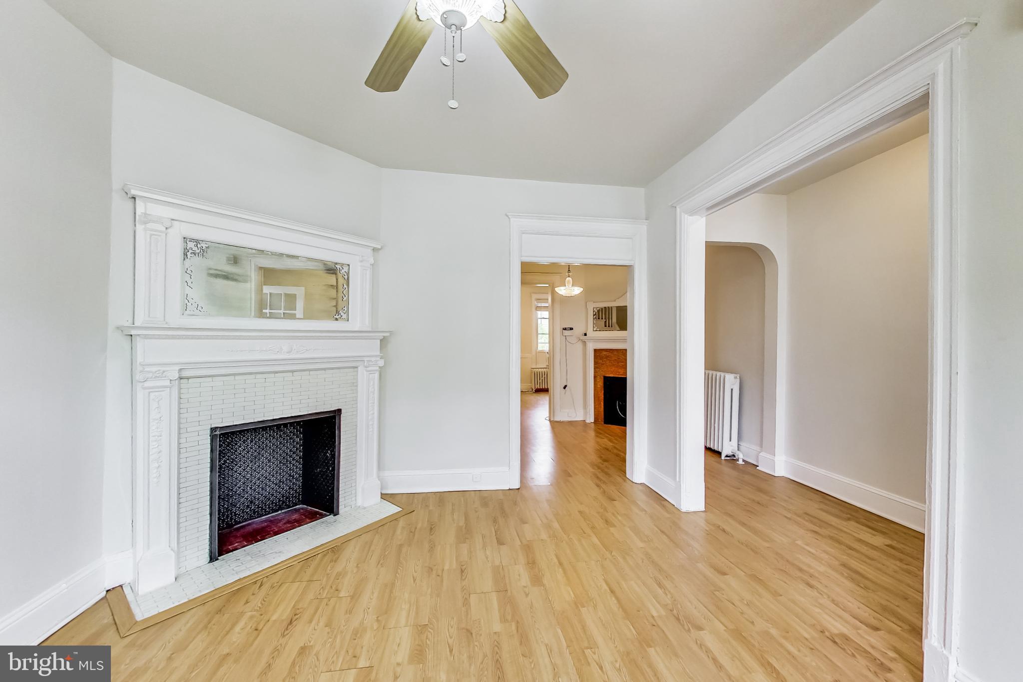 137 R Street Northeast Washington, DC 20002 - Photo 7 of 28 a view of an empty room with wooden floor fireplace and a window