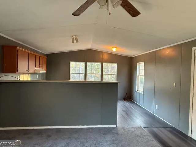 wooden floor in an empty room with a kitchen