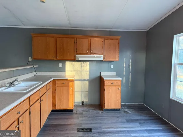 a kitchen with granite countertop wooden floors and a sink