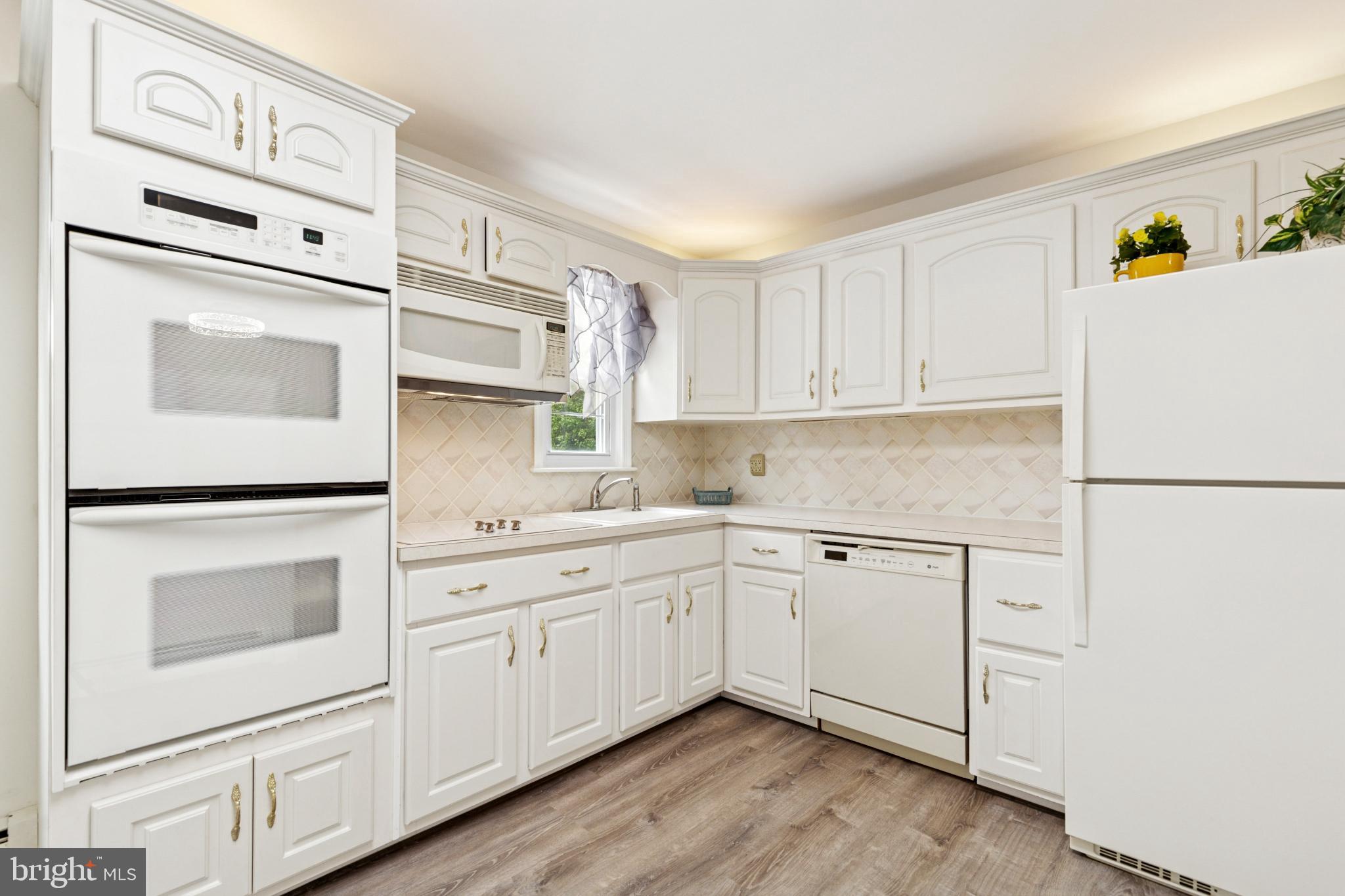 4009 High Point Road Ellicott City, MD 21042 - Photo 24 of 51 a kitchen with white cabinets and white appliances
