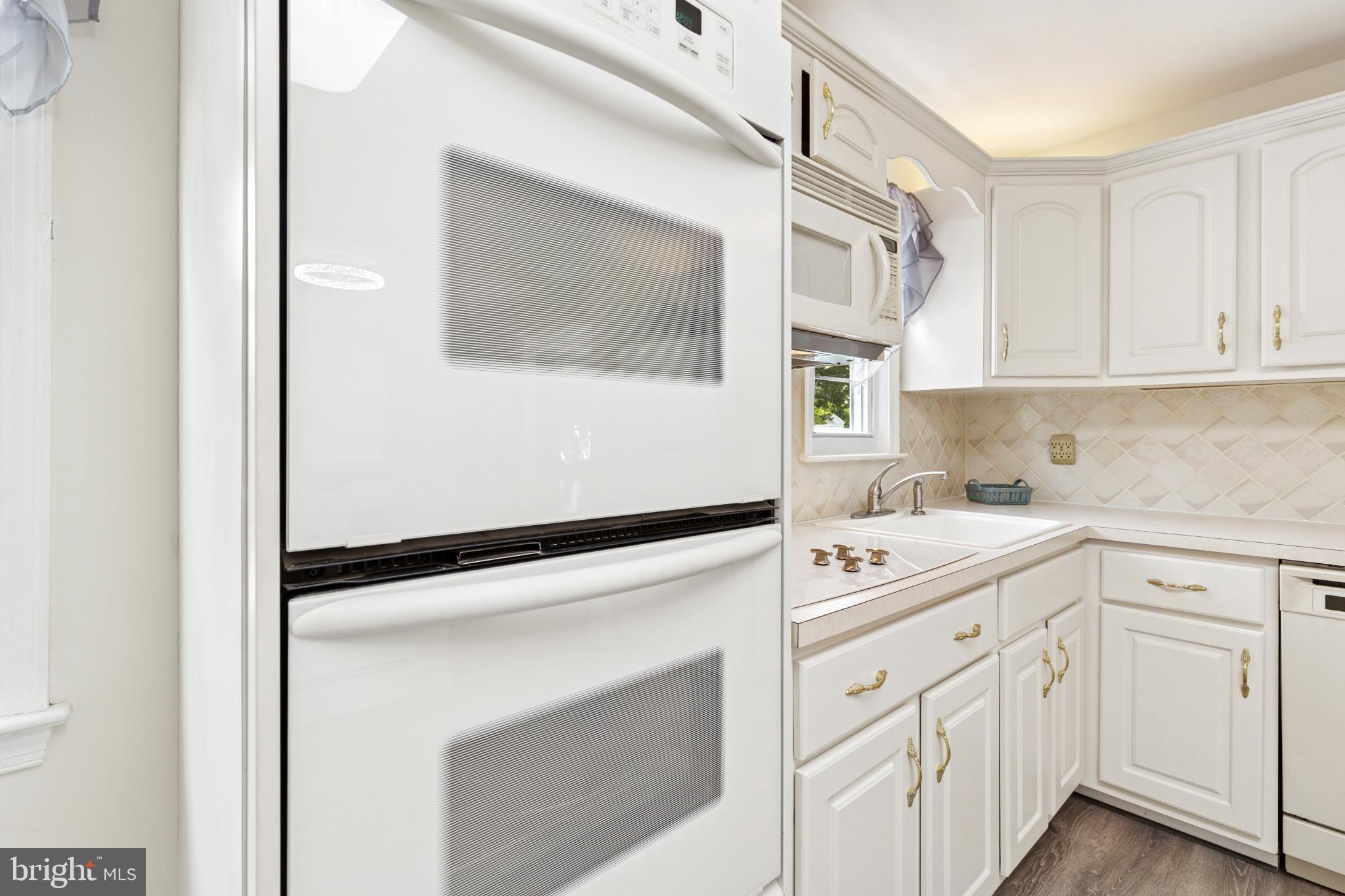 4009 High Point Road Ellicott City, MD 21042 - Photo 25 of 51 a kitchen with white cabinets and white appliances