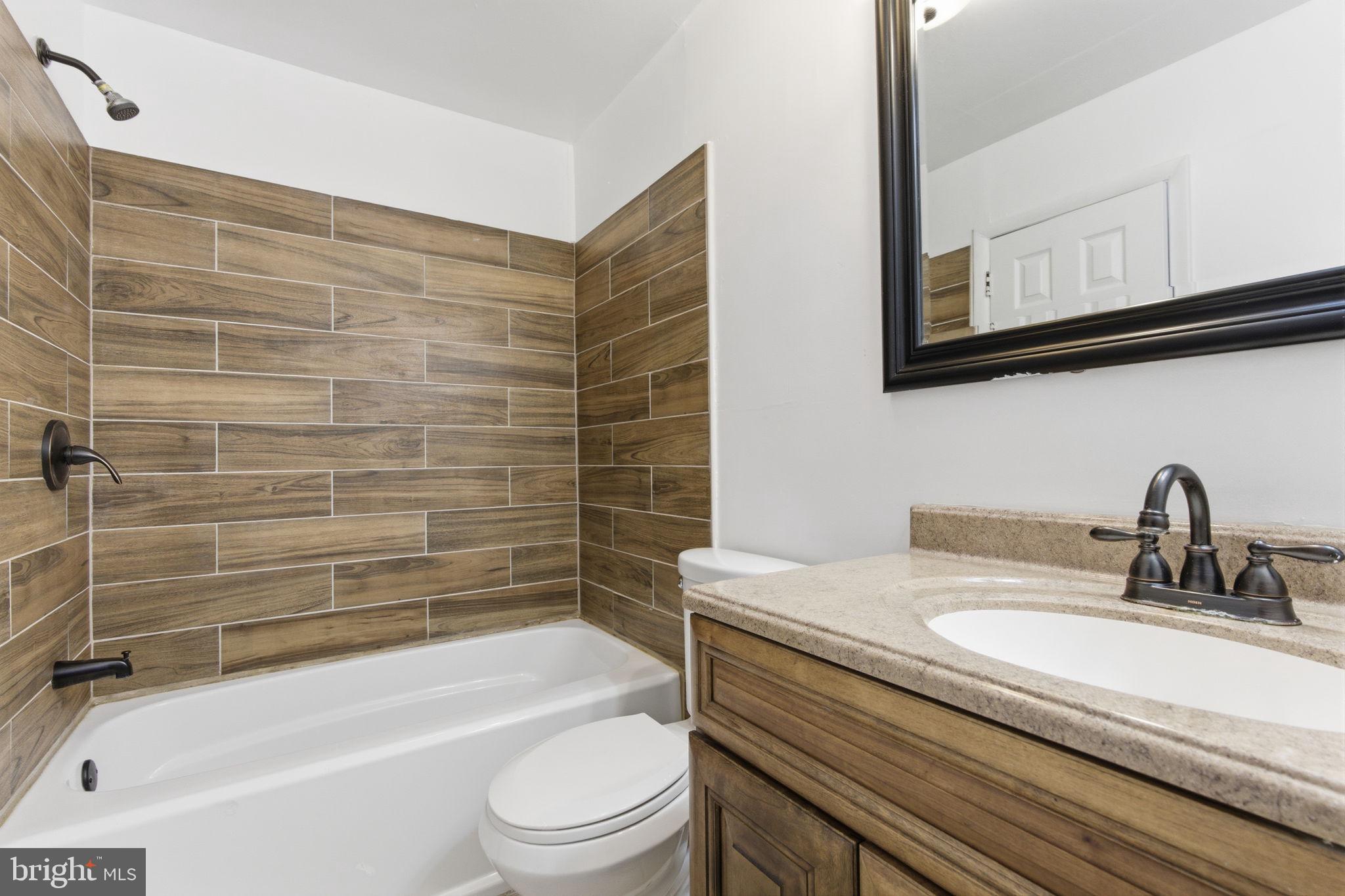 393 Rutgers Court Bensalem, PA 19020 - Photo 12 of 21 a bathroom with a granite countertop bathtub sink vanity mirror and toilet