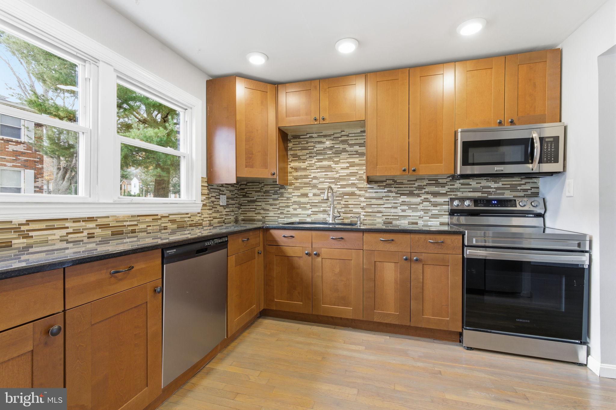 393 Rutgers Court Bensalem, PA 19020 - Photo 3 of 21 a kitchen with stainless steel appliances granite countertop a stove a sink and a microwave
