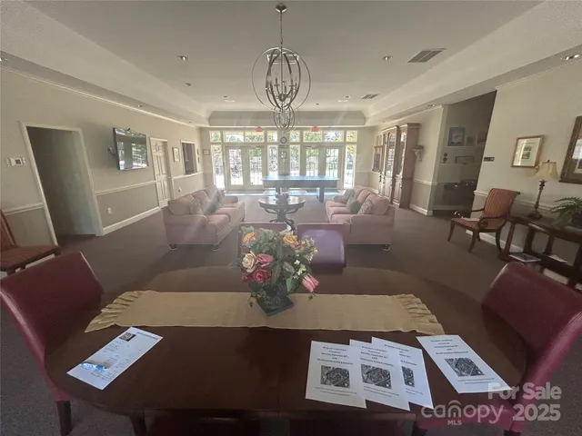 a living room with furniture chandelier and a large window