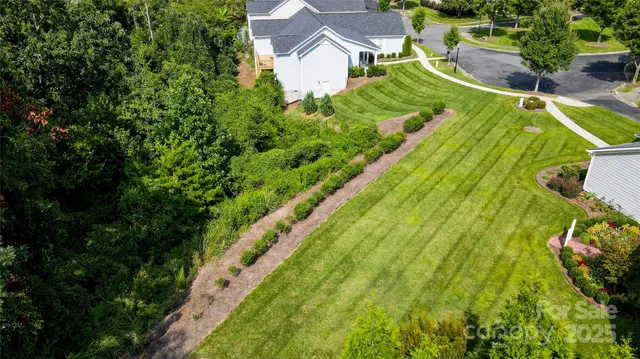 an aerial view of residential houses with outdoor space and trees