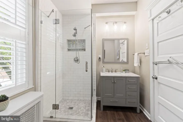a bathroom with a shower sink and mirror