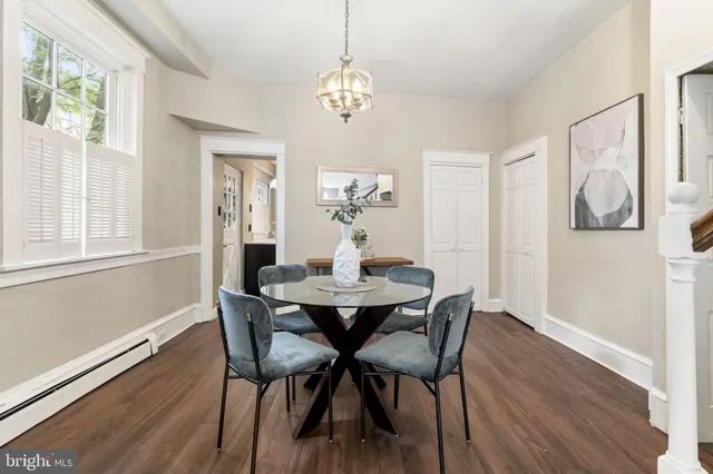 a view of a dining room with furniture a chandelier and wooden floor