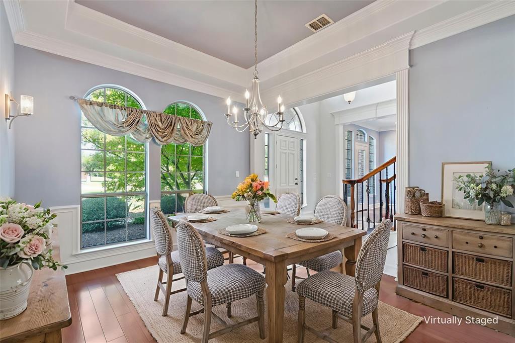 1000 Saddlebrook Drive Lucas, TX 75002 - Photo 10 of 39 Dining space with a tray ceiling, wood-type flooring, ornamental molding, a chandelier, and a wainscoted wall
