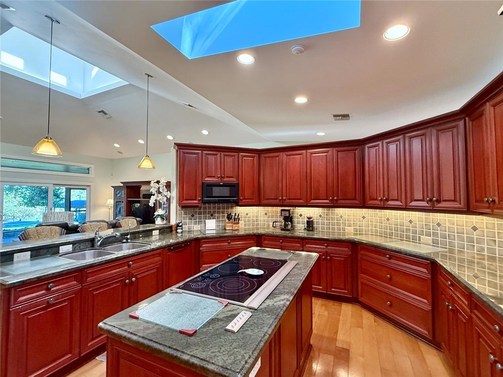 869 Robin Lane Sebastian, FL 32958 - Photo 19 of 35 a kitchen with granite countertop a sink dishwasher stove and cabinets with wooden floor