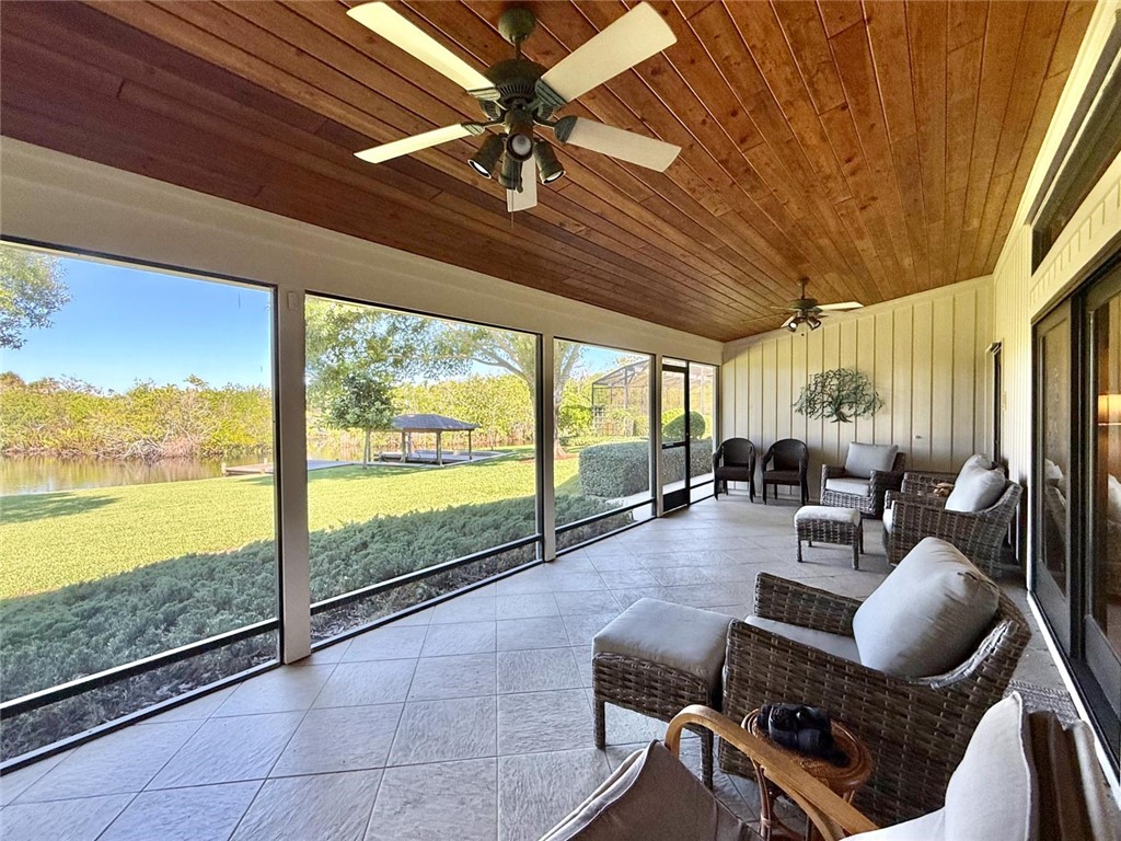 869 Robin Lane Sebastian, FL 32958 - Photo 25 of 35 a living room with furniture floor to ceiling windows and a flat screen tv