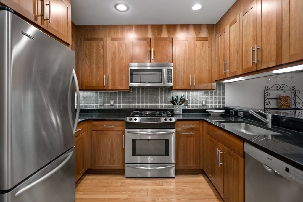 80 Broad Street, Unit 203 Boston, MA 02110 - Photo 3 of 21 a kitchen with a stove and a microwave