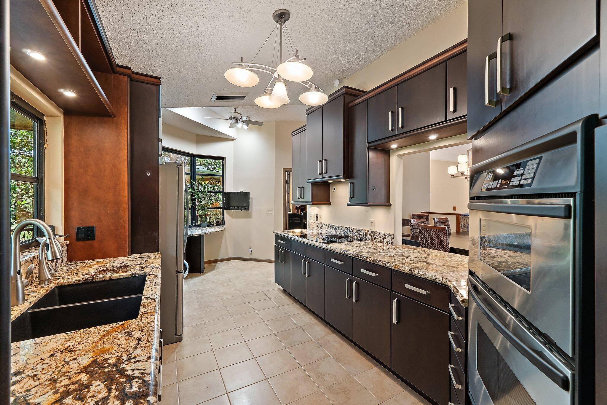 702 Warren Drive Jupiter, FL 33458 - Photo 38 of 76 a large kitchen with stainless steel appliances granite countertop a stove and a sink