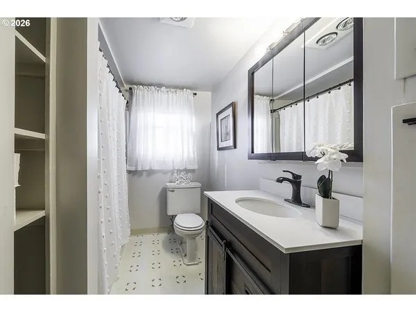 a bathroom with a sink a toilet and a mirror