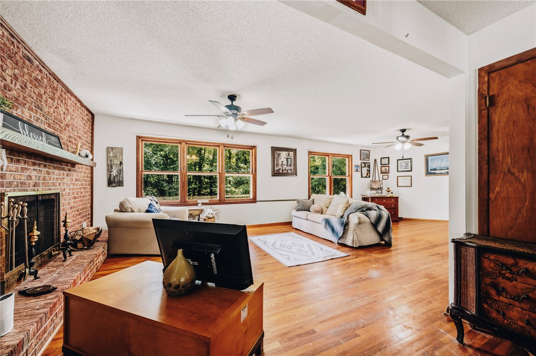 707 Campbell Town Road Walhalla, SC 29691 - Photo 11 of 44 Warm hardwood flooring and a classic brick fireplace anchor this spacious, light-filled living area.