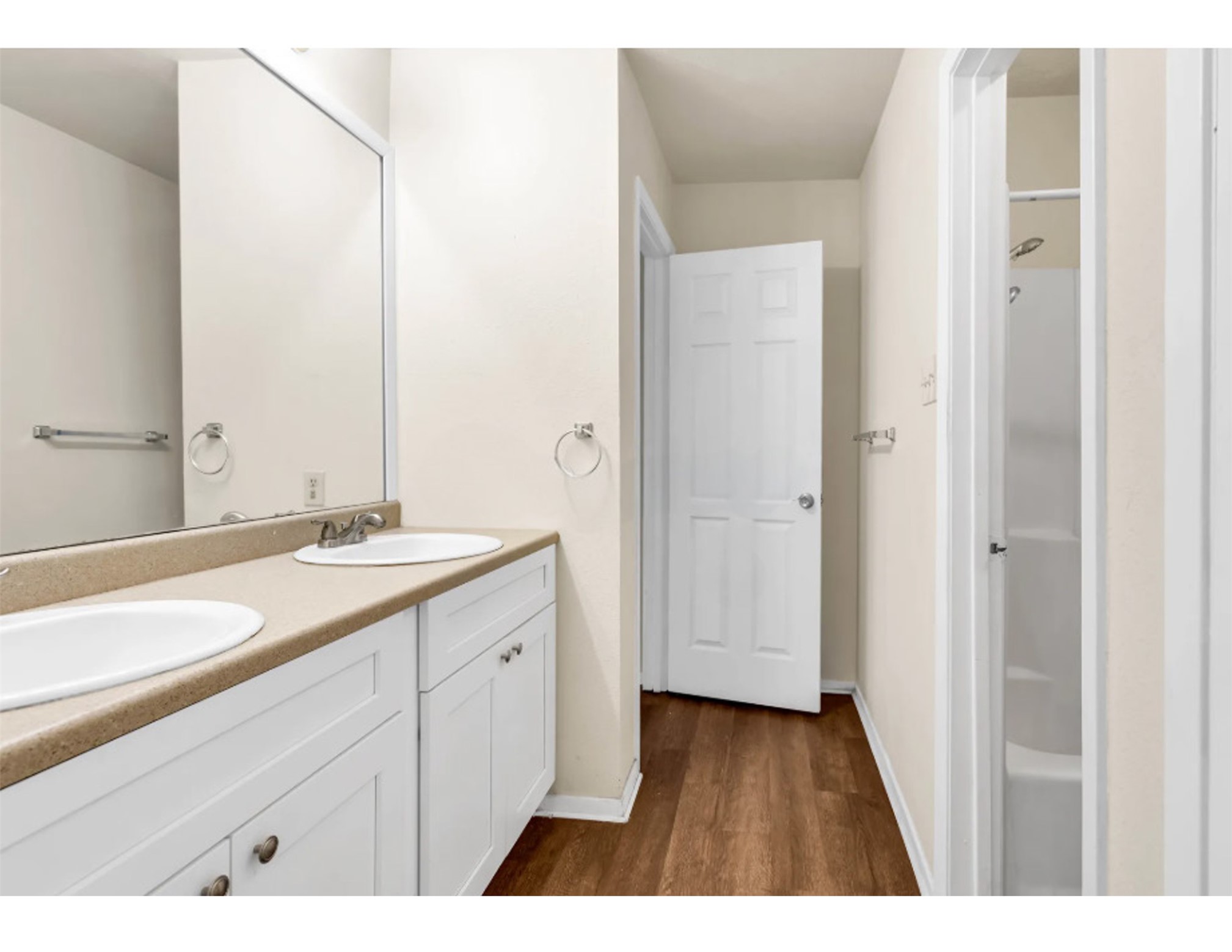 2012 West Loop Austin, TX 78758 - Photo 8 of 16 Bathroom featuring a sink, a shower, wood finished floors, and double vanity