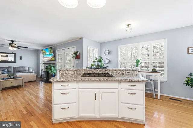 a spacious bathroom with a granite countertop sink mirror and view of living room