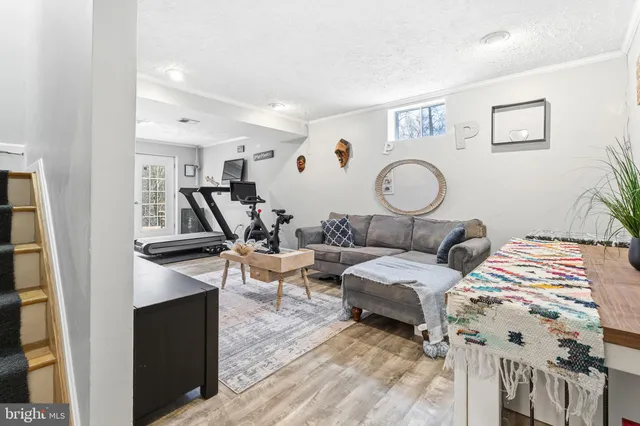 a living room with patio furniture and a wooden floor