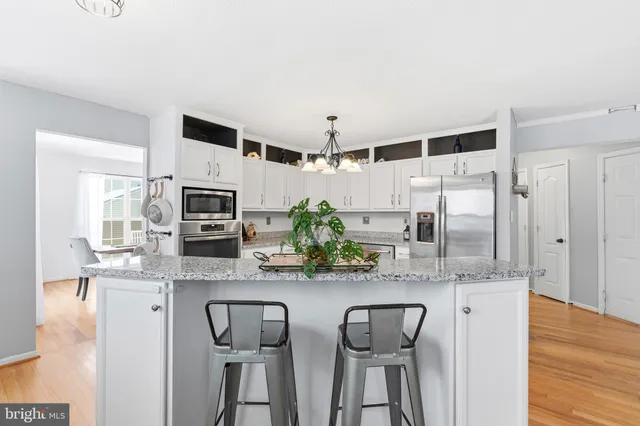 a kitchen with stainless steel appliances a microwave a sink and cabinets