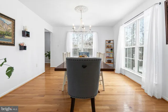a dining room with table chairs and wooden floor