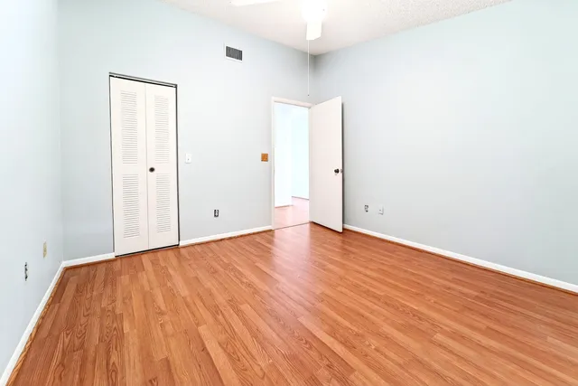 a view of an empty room with wooden floor
