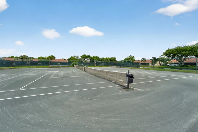 a tennis court with trees in the background