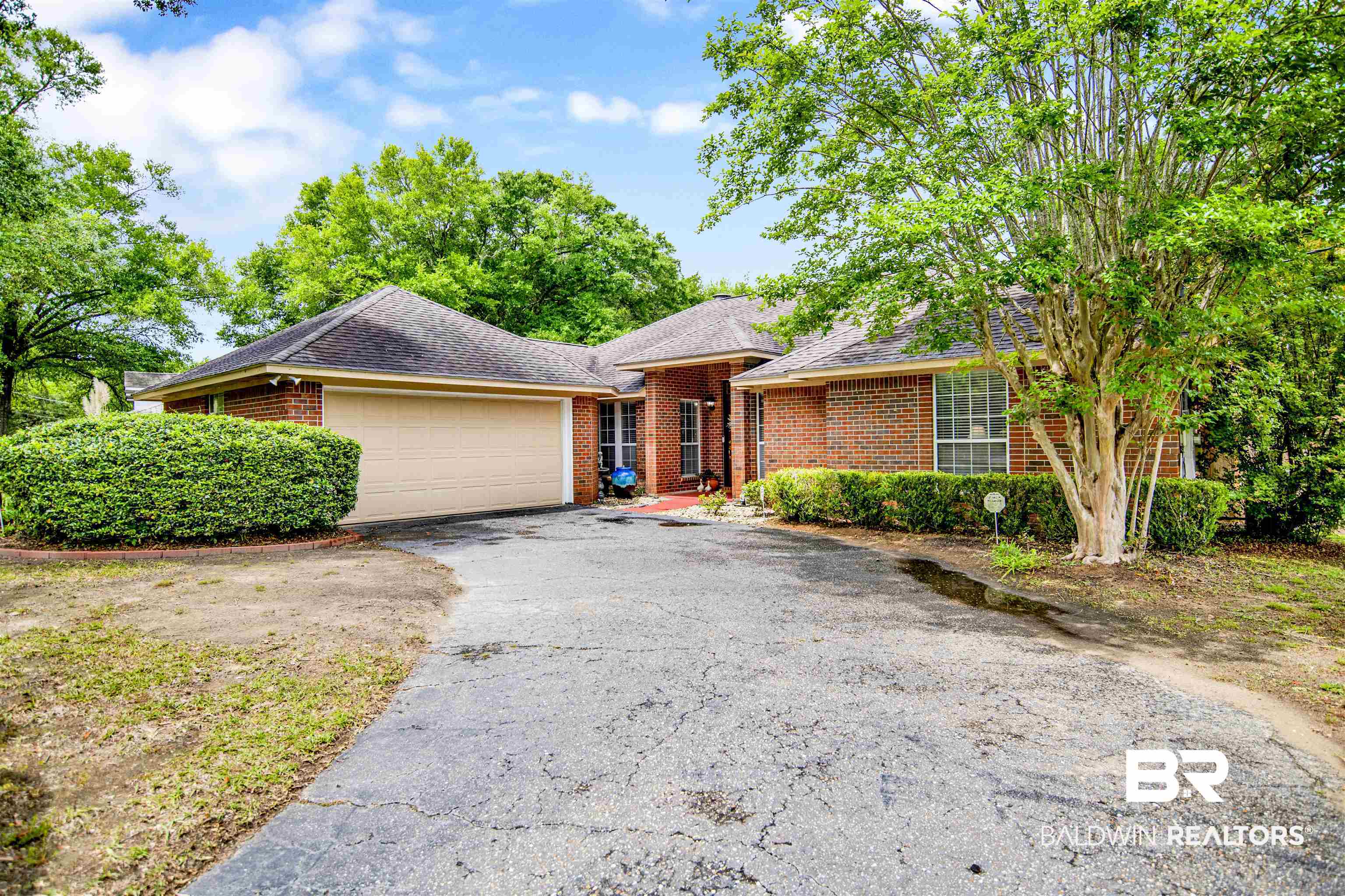 107 Virginia Circle Daphne, AL 36526 - Photo 1 of 47 Brick exterior home featuring a two-car garage, mature landscaping, and a sloped driveway