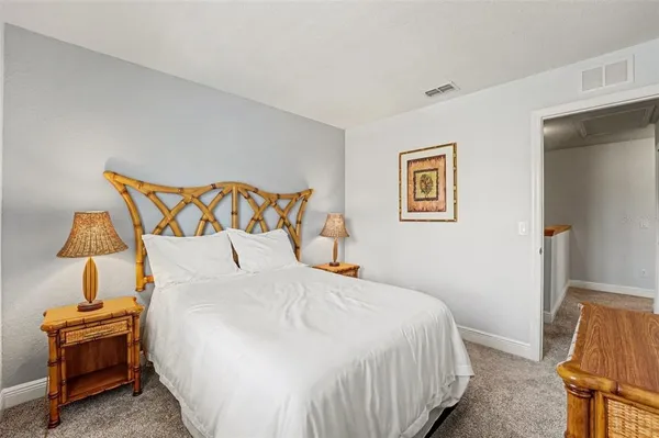 a bedroom with a bed and a lamp on the dresser