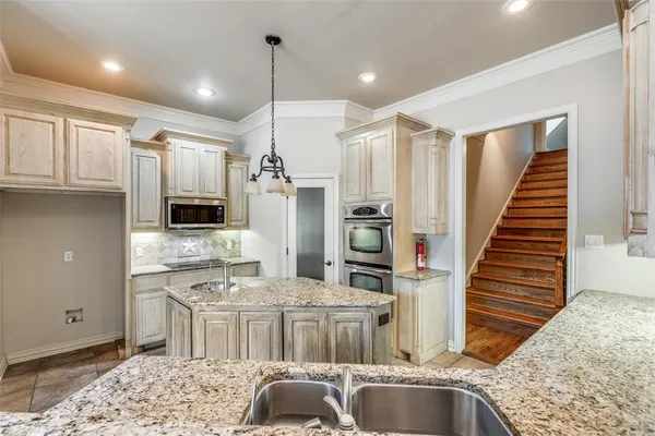 a kitchen with stainless steel appliances granite countertop a sink and a refrigerator