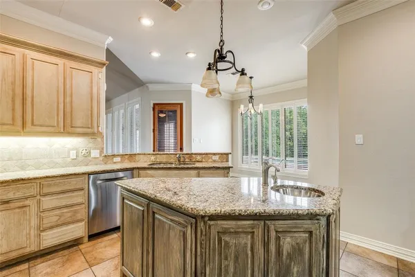 a kitchen with granite countertop stainless steel appliances a sink stove and cabinets