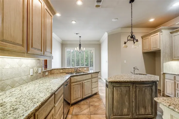 a kitchen with granite countertop a sink and a refrigerator
