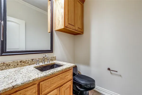 a bathroom with a granite countertop sink a toilet and a mirror