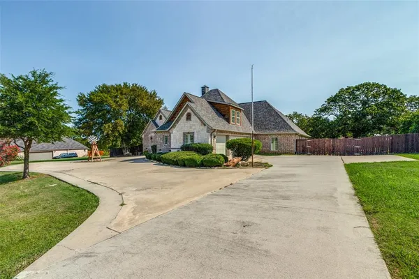 a front view of a house with a yard and trees