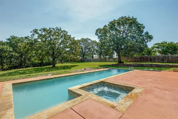 a backyard of a house with lots of green space and fountain
