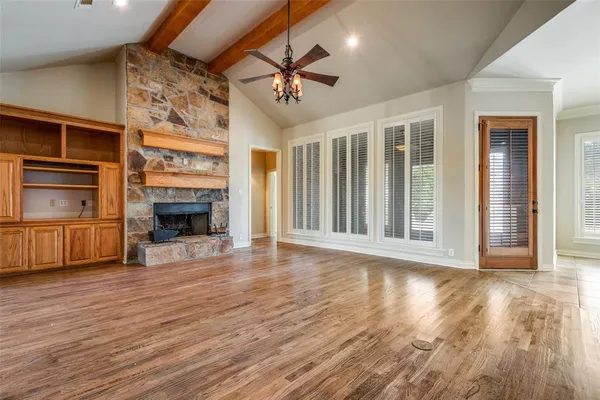 a view of a livingroom with a fireplace a ceiling fan and windows