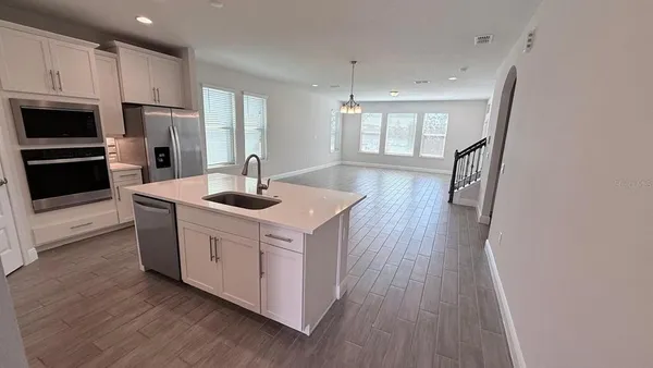 a kitchen with stainless steel appliances granite countertop a refrigerator a stove a sink and a microwave