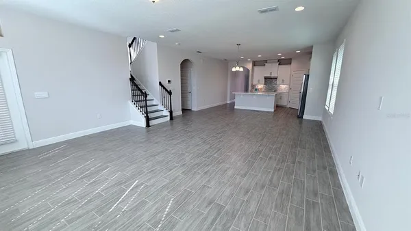 a view of a hallway with wooden floor and a living room