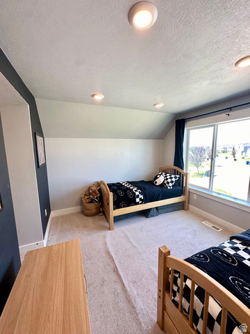 1148 290 South Logan, UT 84321 - Photo 28 of 34 Recessed ceiling lighting, sloped ceiling detail, large window with dark-toned drapery, and neutral-toned carpeting