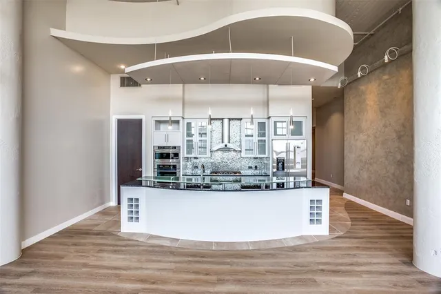 a room with kitchen island a counter top space and wooden floor