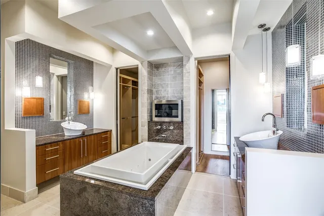 a spacious bathroom with a granite countertop sink a mirror and shower