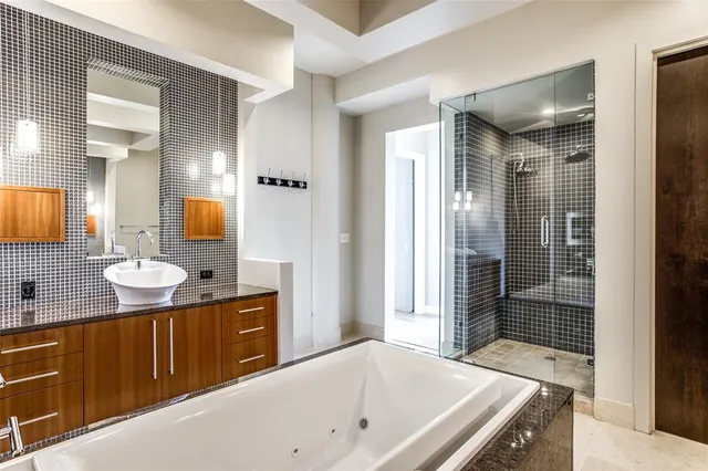 a bathroom with a tub sink shower and mirror