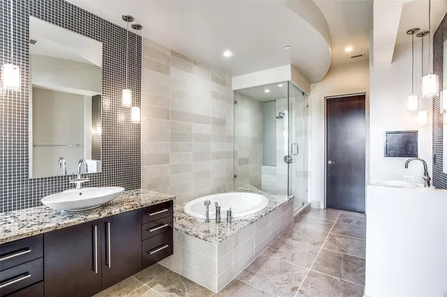 a spacious bathroom with a granite countertop tub sink and mirror