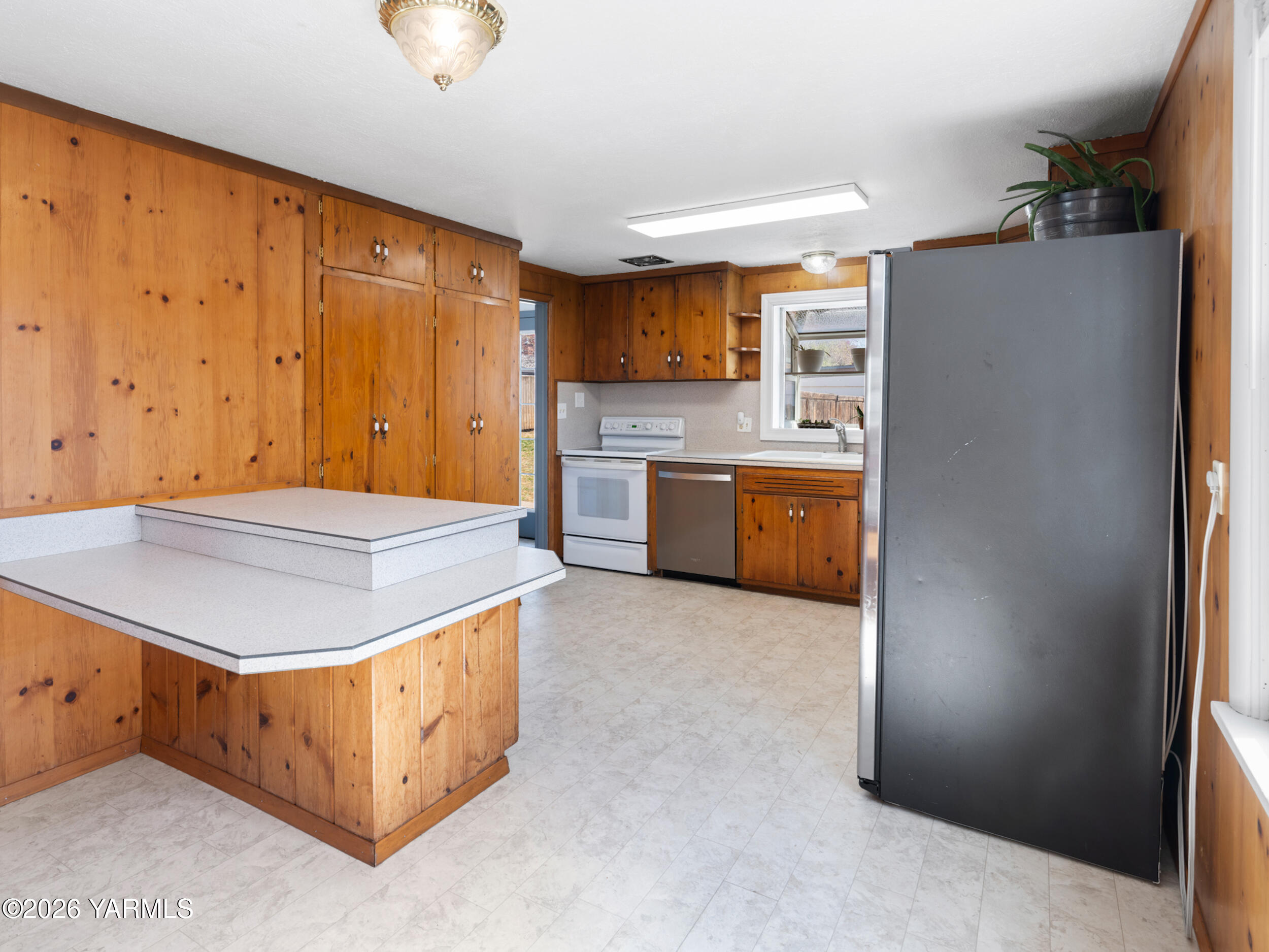 423 South 41st Street Yakima, WA 98901 - Photo 6 of 29 a kitchen with stainless steel appliances granite countertop a refrigerator a oven a sink with wooden cabinets and wooden floor