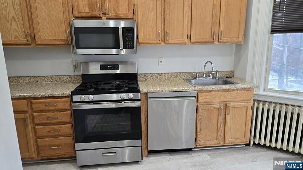 154 Undercliff Avenue, Unit 5 Edgewater, NJ 07020 - Photo 11 of 13 a kitchen with granite countertop white cabinets and stainless steel appliances