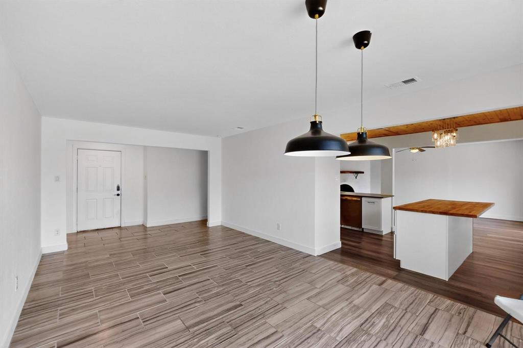 4857 Fallon Place Dallas, TX 75227 - Photo 9 of 19 Unfurnished living room with wood tiled floors and a chandelier