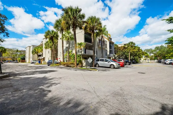 a view of road with card parked on side and retail shops