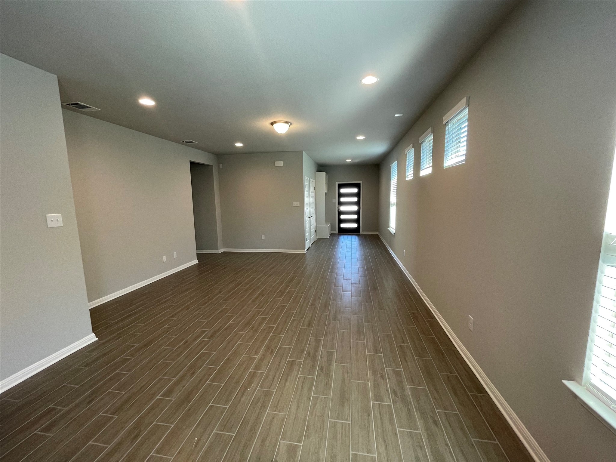 125 Unforgiven Lane Jarrell, TX 76537 - Photo 4 of 17 a view of an empty room with wooden floor and a window